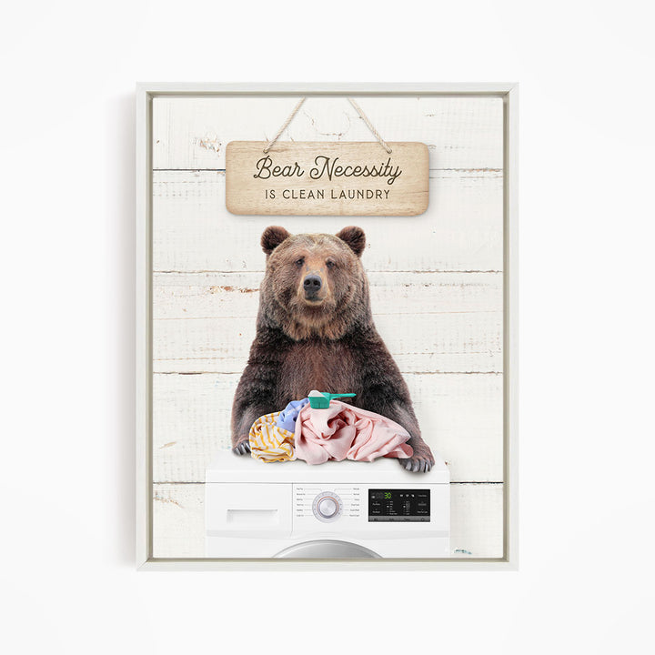 A brown bear sitting on top of a washing machine, with a sign above that says "Bear Necessity is Clean Laundry".