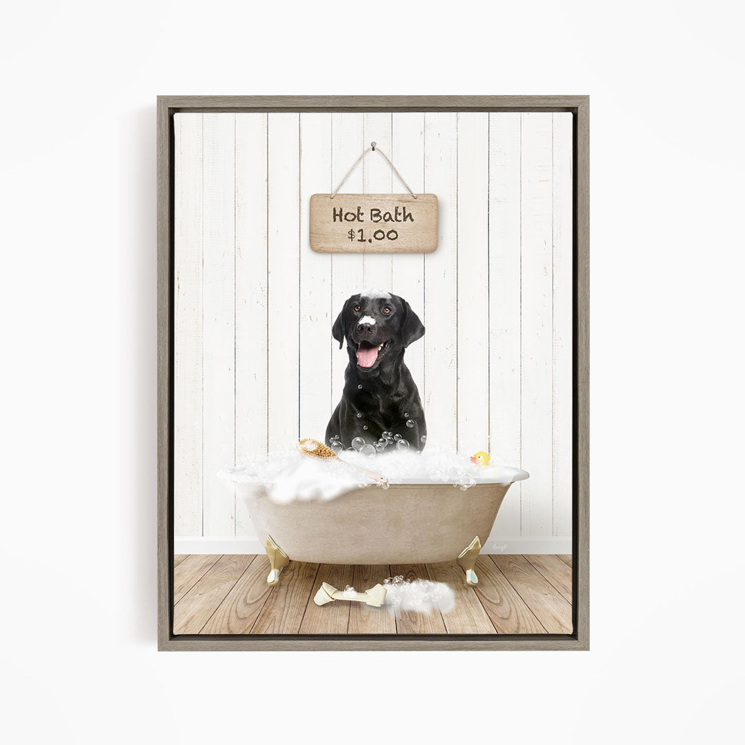 A black dog sitting in a white bathtub filled with bubbles, with a sign above the tub indicating a hot bath for $1.00.