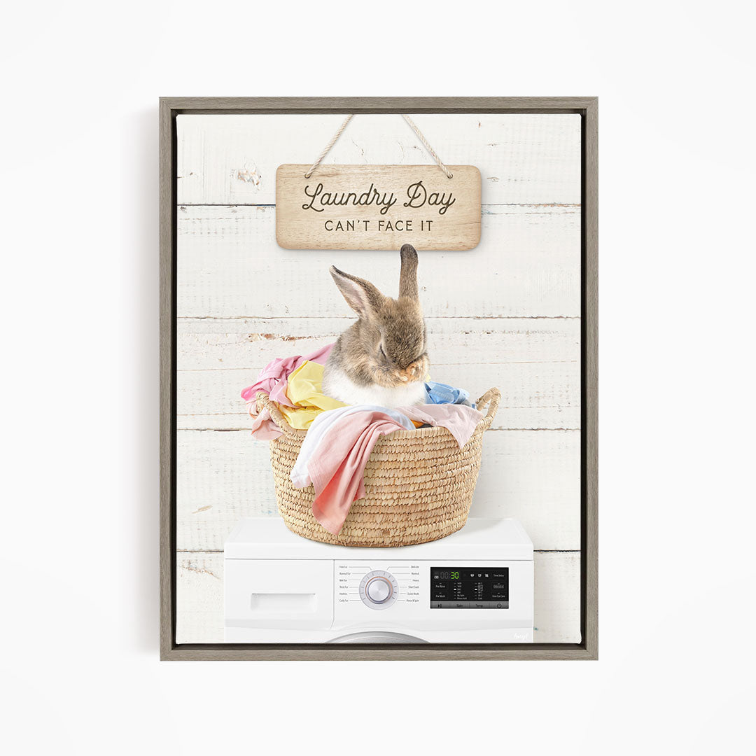 A cute rabbit sitting in a woven laundry basket, with a sign above that says "Laundry Day Can't Face It".