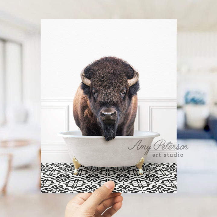 a hand holding a card with a picture of a bison in a bathtub