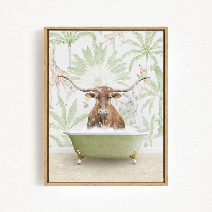 A brown cow with large horns is sitting in a green bathtub filled with water, surrounded by tropical foliage.