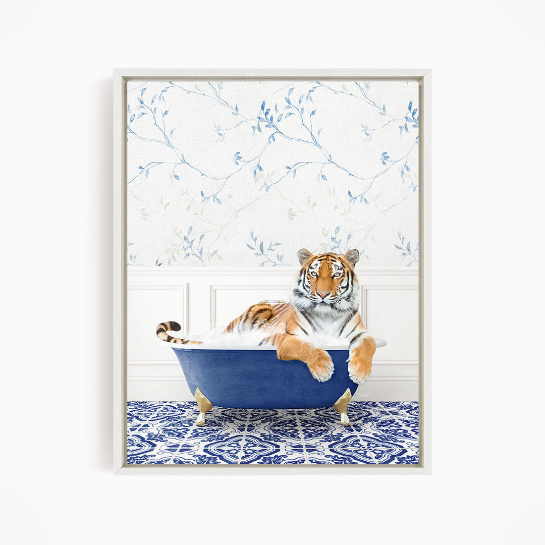 A tiger is sitting in a blue bathtub, surrounded by a blue and white patterned floor.