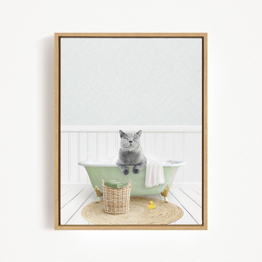 A gray cat sitting in a green bathtub filled with bubbles, surrounded by a basket of toys and a yellow rubber duck.
