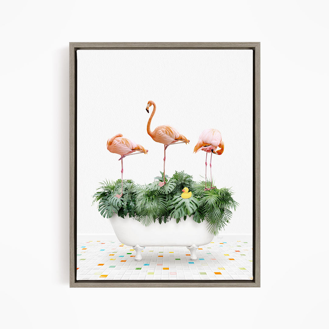 A framed image depicting three flamingos standing on a bathtub filled with green plants and a yellow rubber duck.