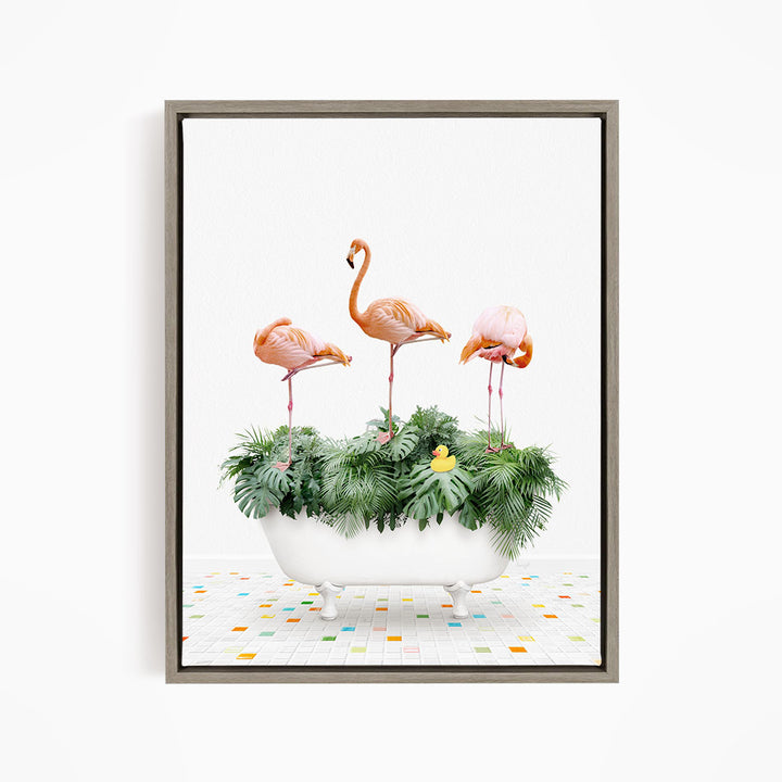 A framed image depicting three flamingos standing on a bathtub filled with green plants and a yellow rubber duck.