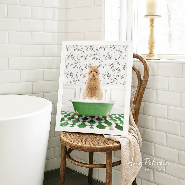 A framed image of a small dog sitting in a green bathtub, surrounded by a floral pattern, is displayed on a wooden chair in a bathroom setting.