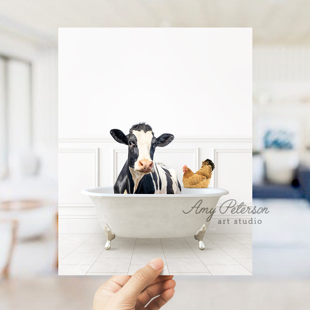 a hand holding up a card with a picture of a cow in a bathtub