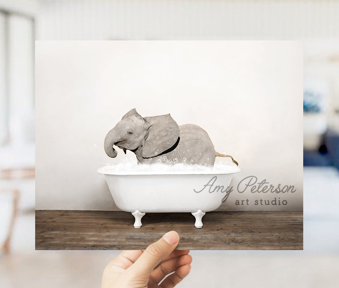 a hand holding up a card with an elephant in a bathtub