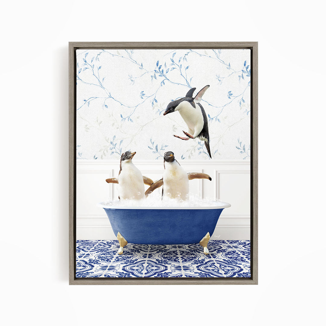 A framed image depicting two penguins sitting in a blue bathtub, with one penguin flying towards the other in mid-air.