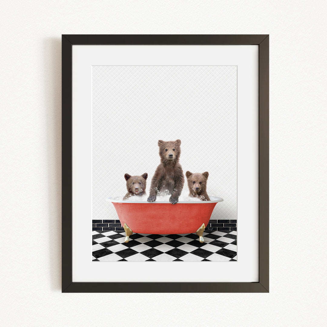A framed image depicting three brown bears sitting in a red bathtub on a black and white checkered floor.