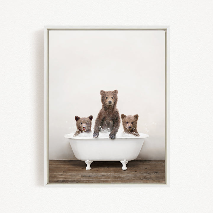Three adorable brown bears sitting in a white bathtub, enjoying a relaxing bath together.