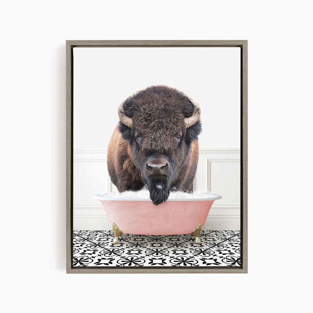 A buffalo with large horns is standing in a pink bathtub, looking directly at the camera.