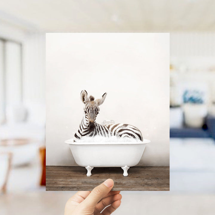 A zebra lying in a white bathtub, surrounded by a blurred background.