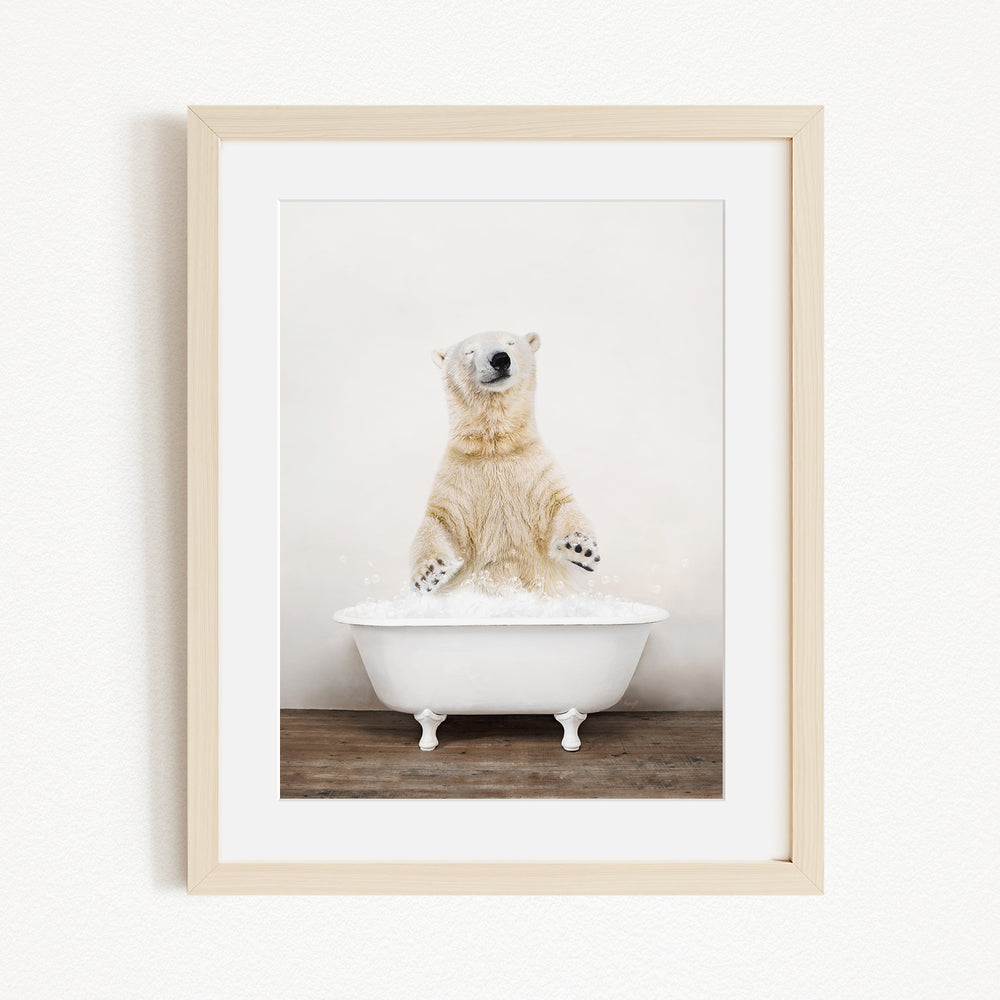 A polar bear standing in a white bathtub filled with water, appearing to be enjoying a bath.