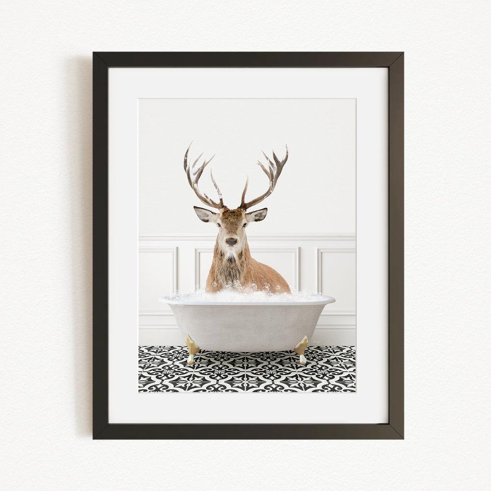 A deer with large antlers is sitting in a white bathtub filled with water, creating a whimsical and unexpected scene.