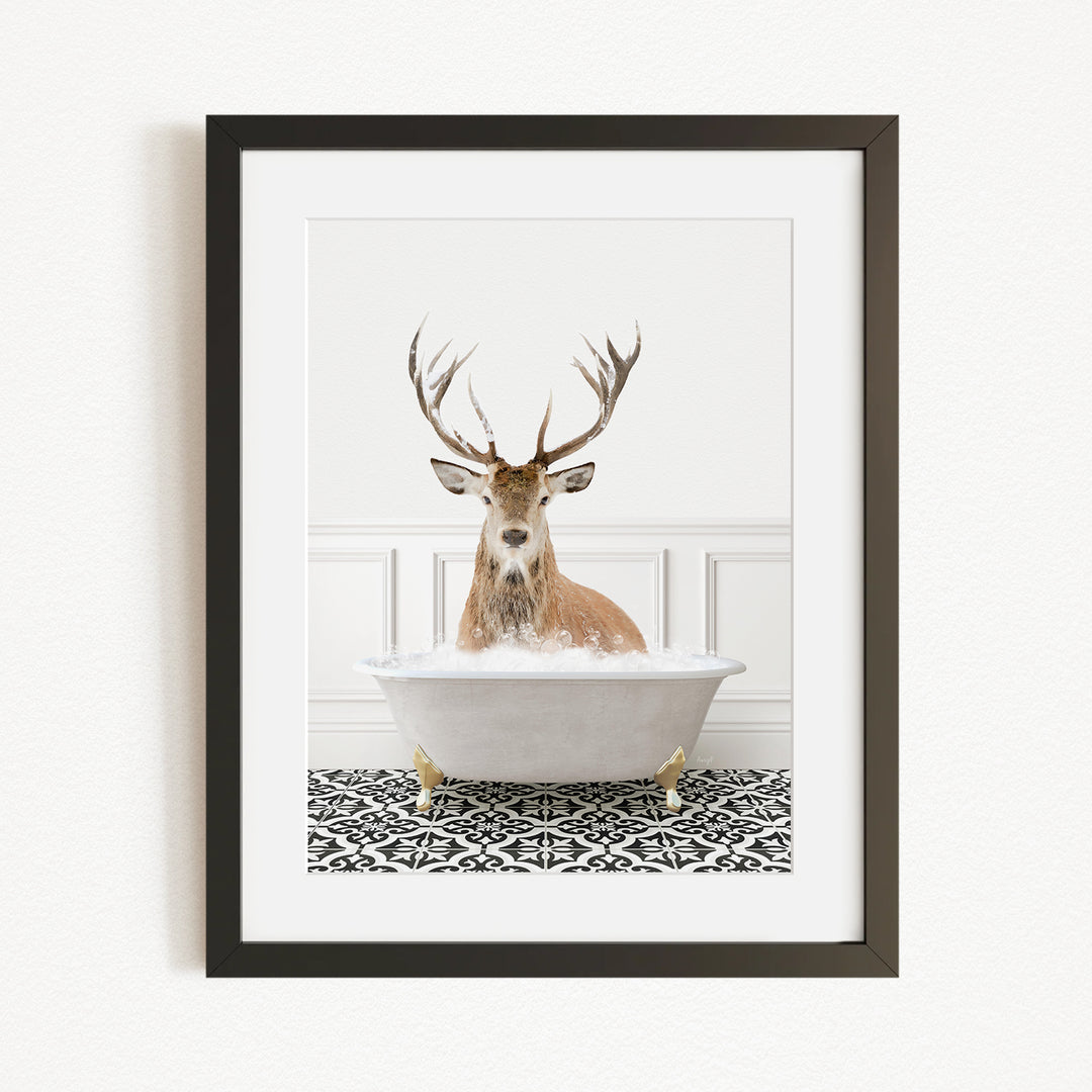 A deer with large antlers is sitting in a white bathtub filled with water, creating a whimsical and unexpected scene.