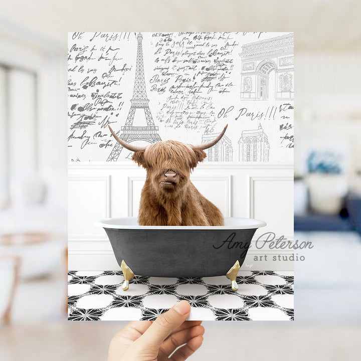 a hand holding up a card with a picture of a cow in a bathtub