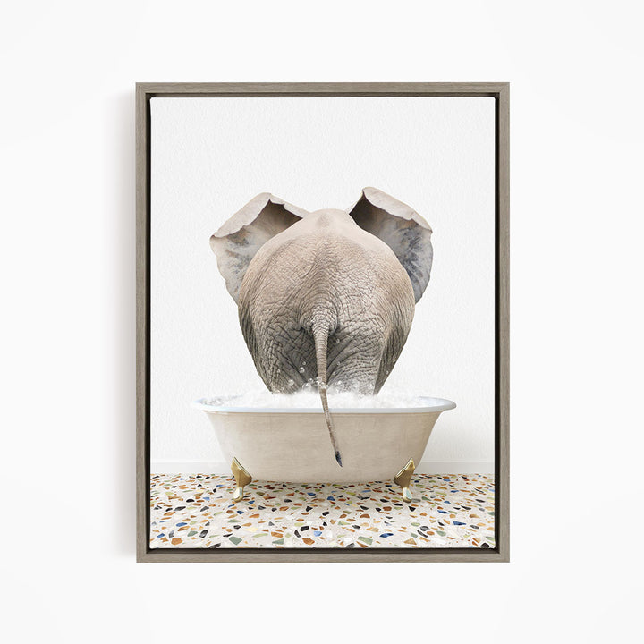 A gray elephant is standing in a white bathtub filled with water, with its trunk submerged in the water.