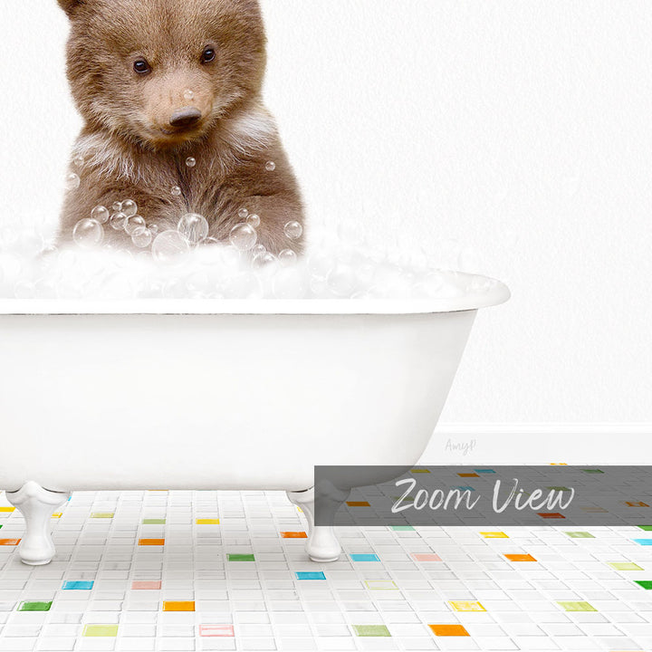 A cute brown bear cub sitting in a white bathtub filled with bubbles, surrounded by a colorful tiled floor.