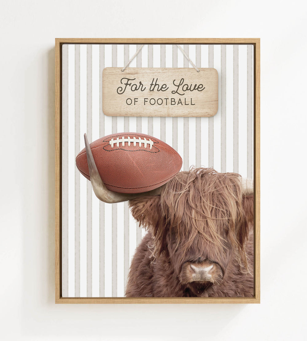 A framed image featuring a Highland cow with a football on its head, accompanied by a wooden sign that reads "For the Love of Football".