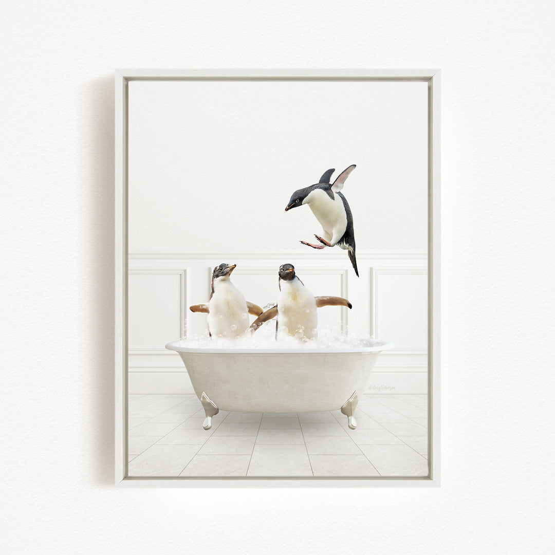 A framed image depicting two penguins sitting in a bathtub, with one penguin jumping out of the tub.