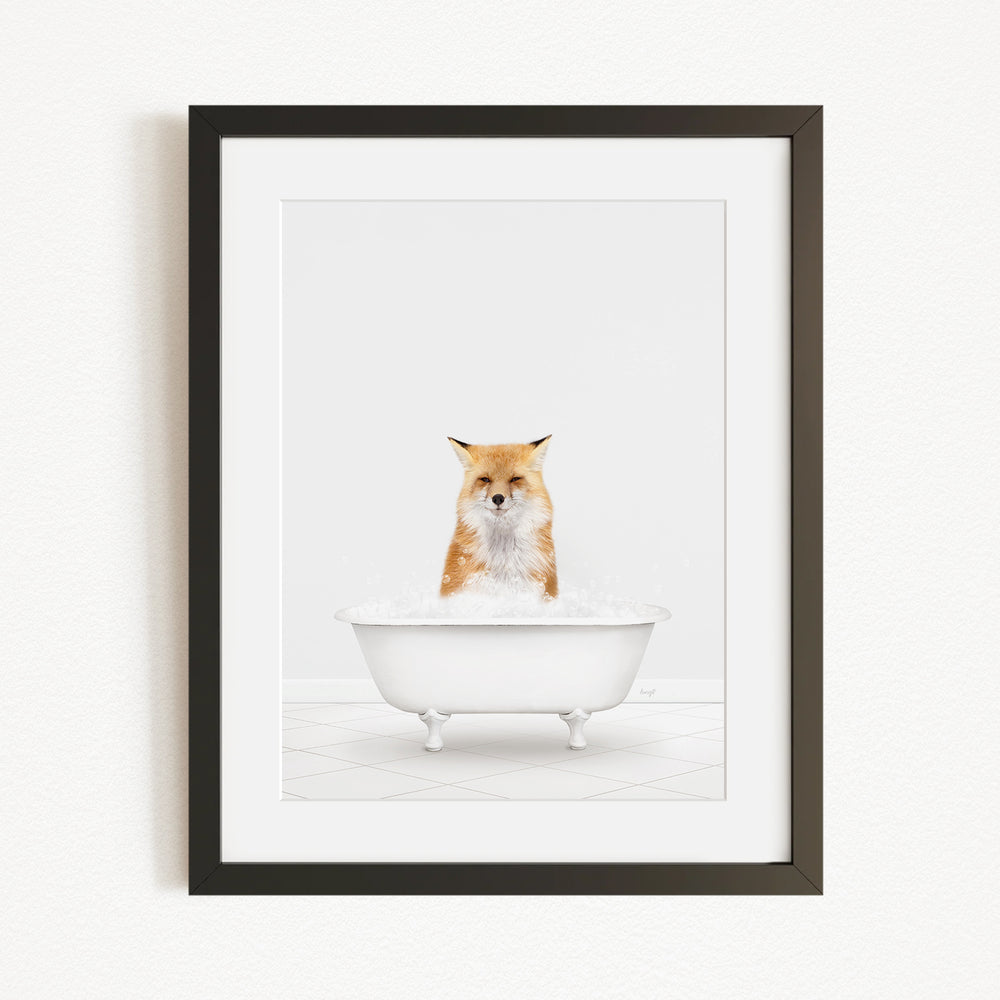 A framed image of a fox sitting in a white bathtub filled with bubbles.