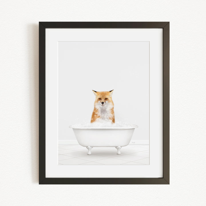 A framed image of a fox sitting in a white bathtub filled with bubbles.