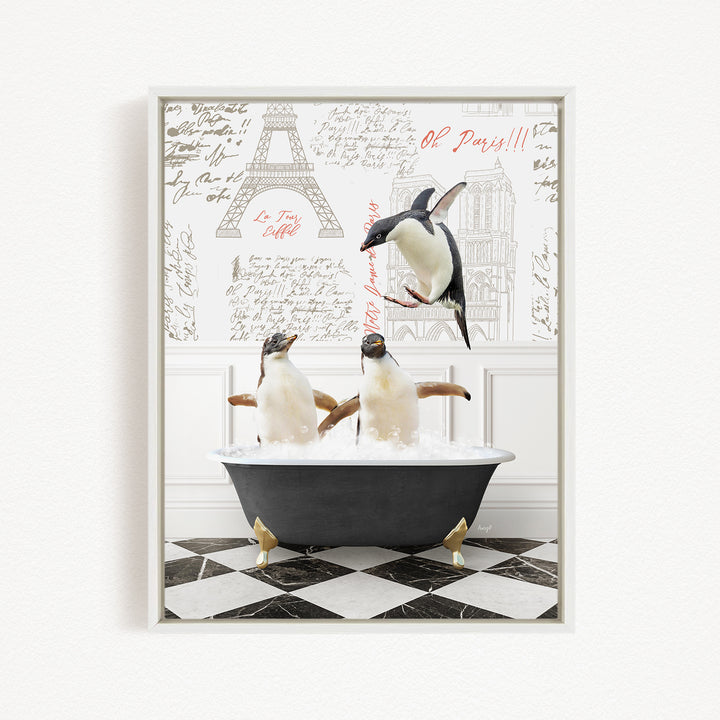 A framed image depicting three penguins sitting in a bathtub, with one penguin flying above the tub and another penguin sitting in the tub. The background features a wall with text and drawings, including the Eiffel Tower.