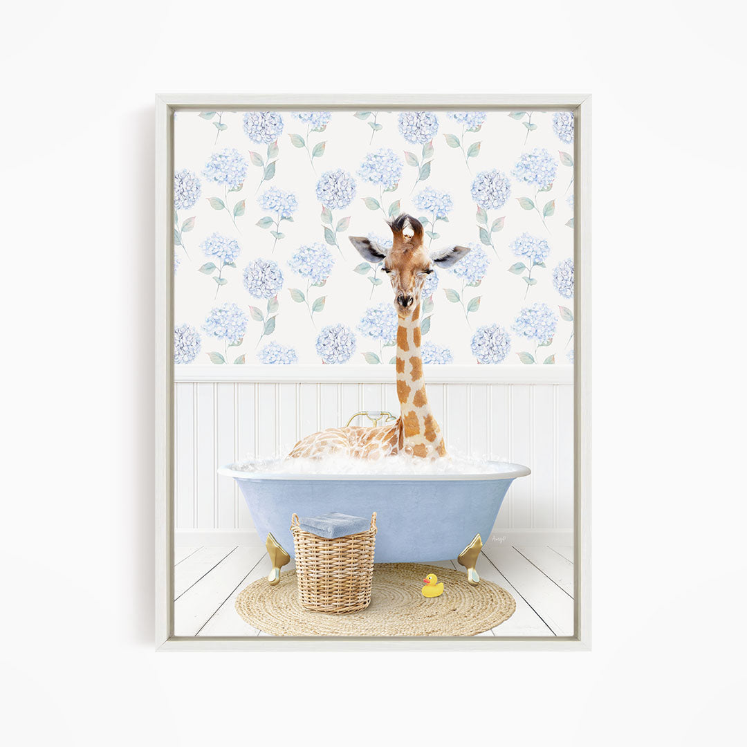 A giraffe is sitting in a blue bathtub filled with water, surrounded by a wicker basket and a yellow rubber duck.