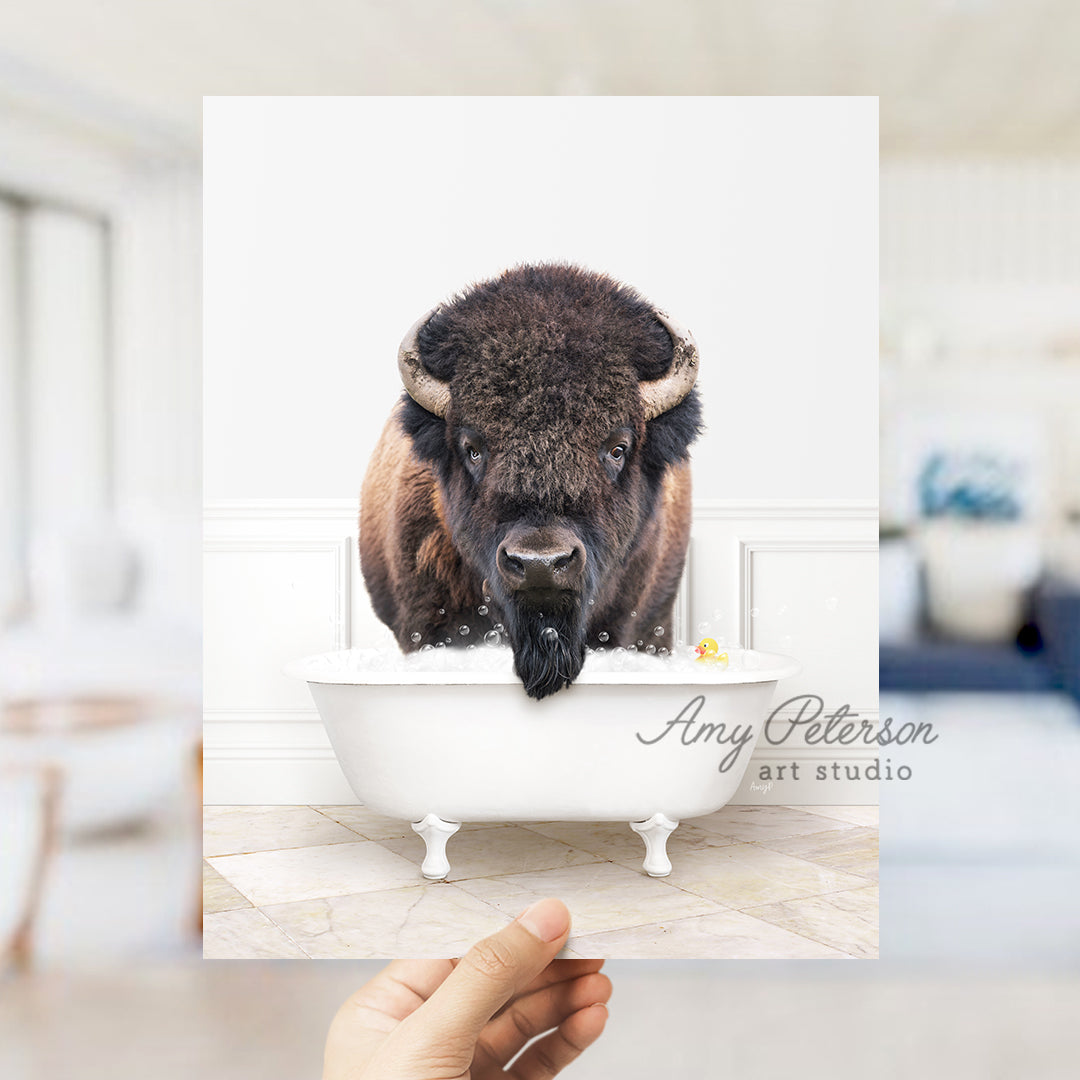 a person holding up a picture of a bison in a bathtub