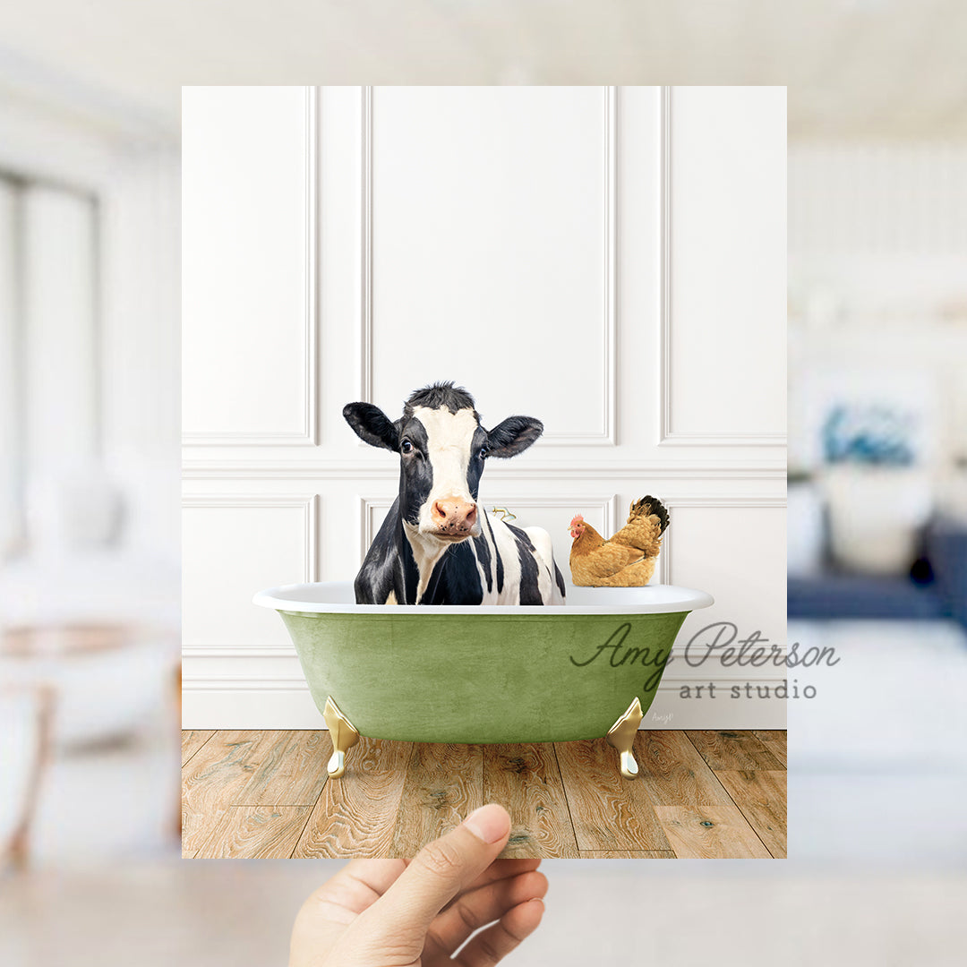 a hand holding a photo of a cow in a bathtub