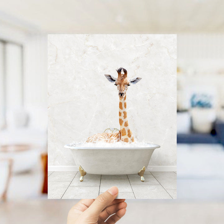 A giraffe sitting in a bathtub filled with bubbles, with a hand holding up the image to show it.