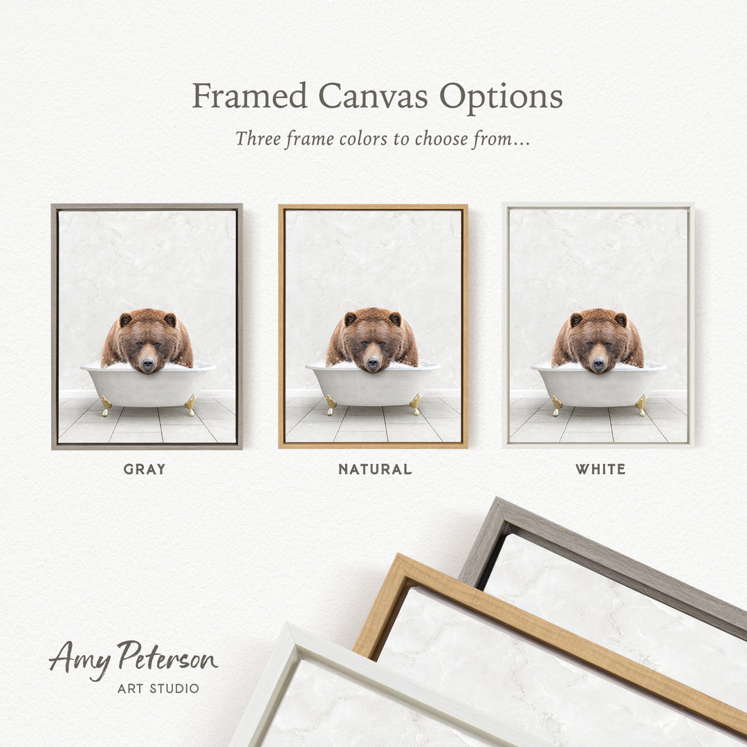three framed canvas options, each featuring a brown bear sitting in a bathtub. The options include a gray frame, a natural frame, and a white frame.