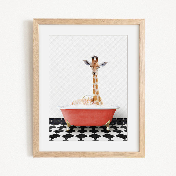 A giraffe sitting in a red bathtub filled with bubbles, surrounded by a black and white checkered floor.