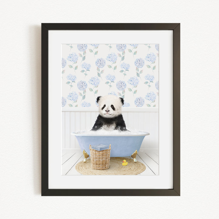 A panda bear sitting in a blue bathtub filled with bubbles, surrounded by a floral patterned wall and a basket of rubber ducks.