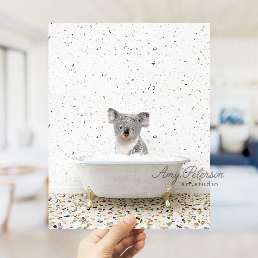 a hand holding a photo of a koala in a bathtub