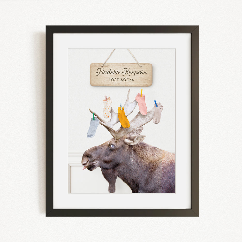 A framed image of a moose with a sign that says "Finders Keepers Lost Socks" hanging above it.