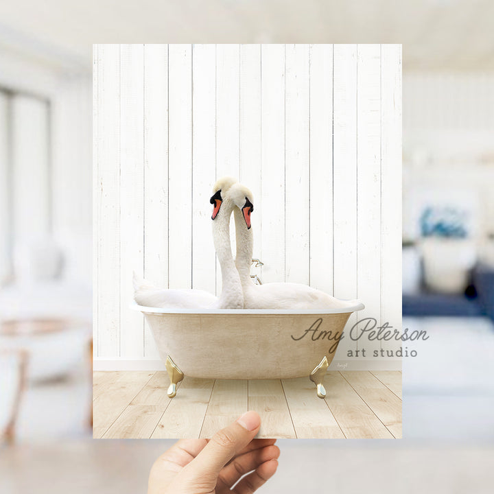 a person holding a picture of a swan in a bathtub