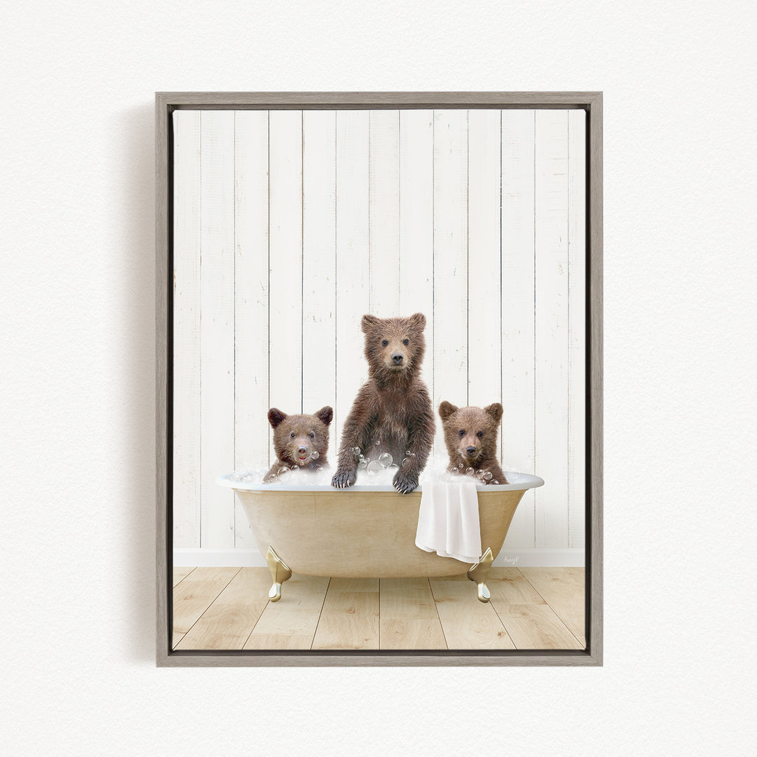 A framed image depicting three brown bears sitting in a bathtub, with one bear sitting in the center and the other two bears sitting on either side.