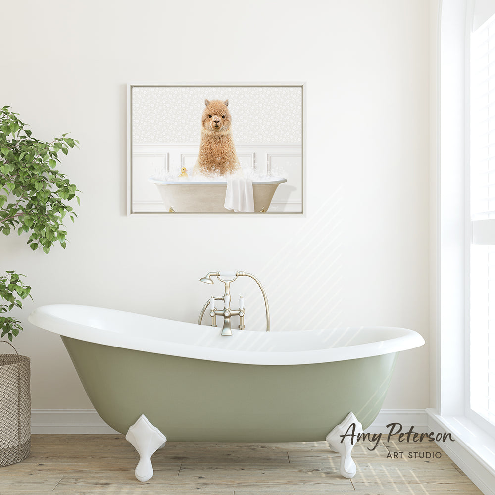 A framed image of a dog sitting in a bathtub is displayed on the wall above a green clawfoot bathtub in a bright, white-walled bathroom.