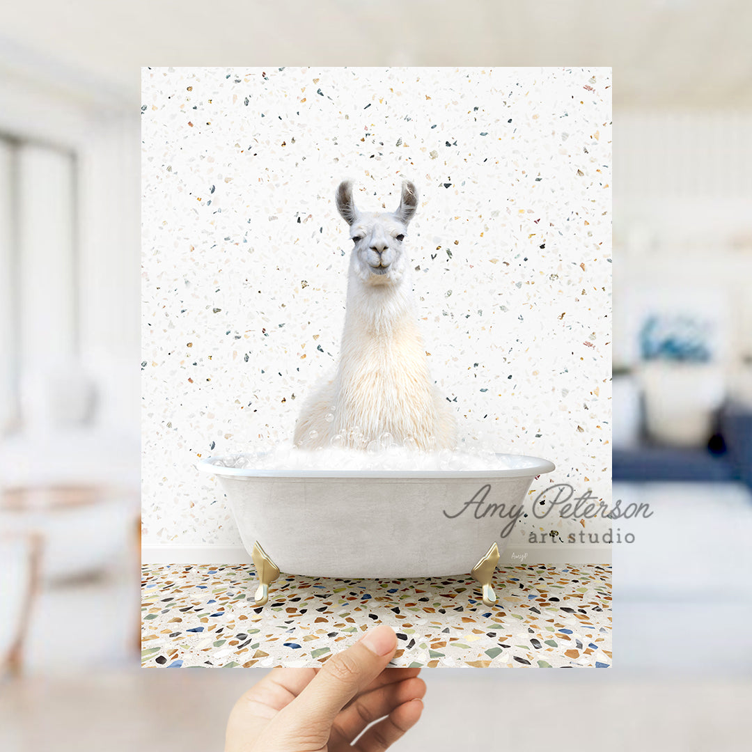 a llama sitting in a bathtub with a hand holding it