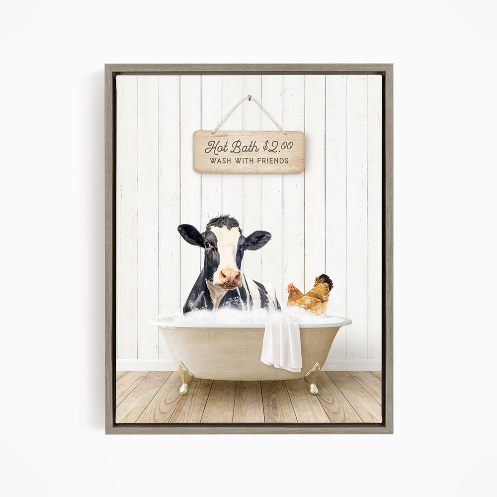 A framed image depicting a cow sitting in a bathtub, with a sign above it that reads "Hot Bath $2.00 WASH WITH FRIENDS".