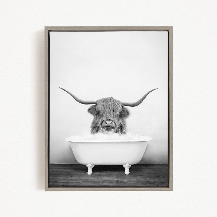 A black and white photograph of a long-haired animal, possibly a yak or a similar species, sitting in a white bathtub filled with water.