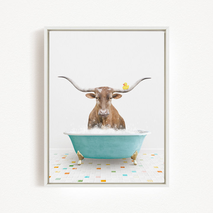A brown cow with long horns is sitting in a blue bathtub, surrounded by a yellow rubber duck.