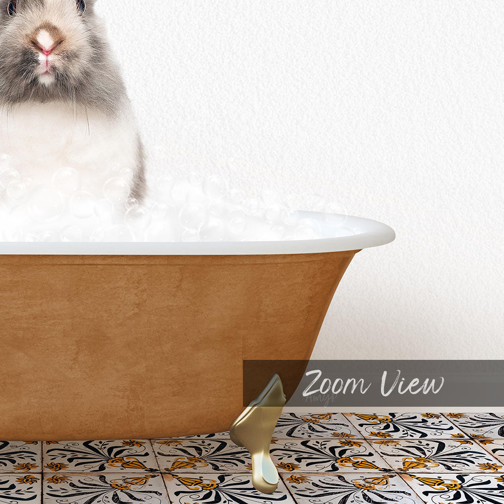 A fluffy gray and white rabbit sitting in a brown bathtub filled with bubbles, with a gold bathtub leg visible on the floor.