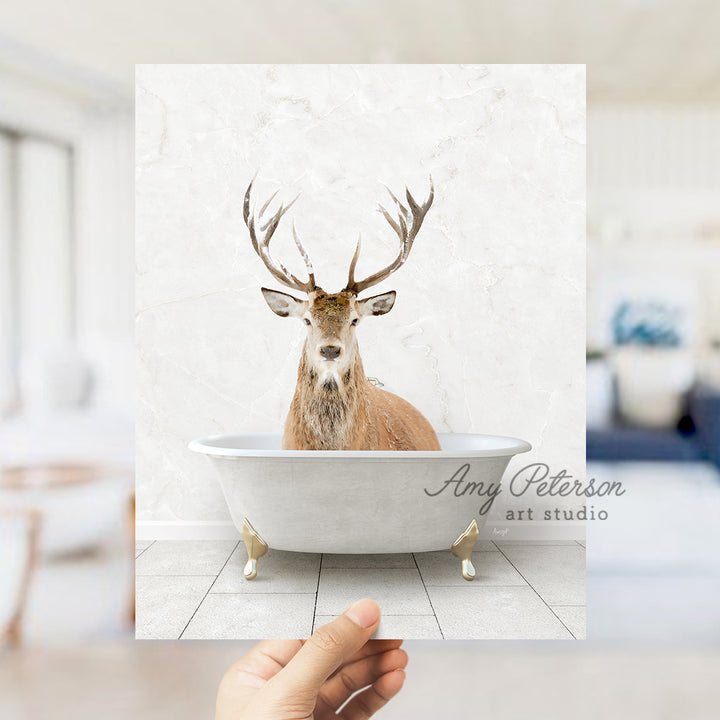 a hand holding a photo of a deer in a bathtub