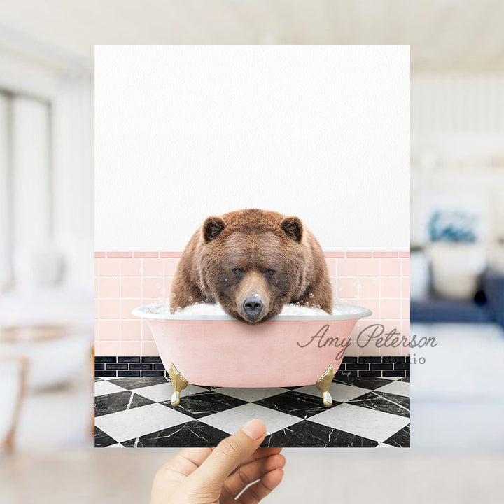 a person holding up a card with a bear in a bathtub