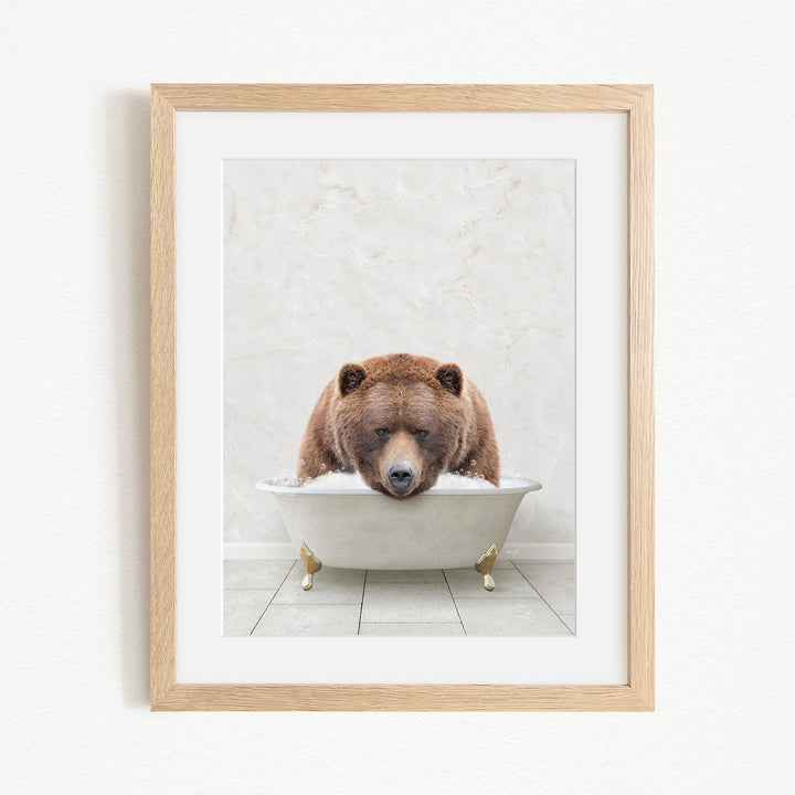 A brown bear is sitting in a white bathtub, appearing relaxed and content.