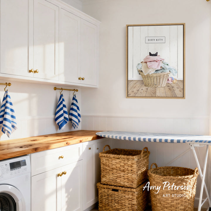 a well-organized laundry room with white cabinets, a wooden countertop, and a framed picture of a cat in a basket. The room also features a washer and dryer, as well as two woven baskets for storage.