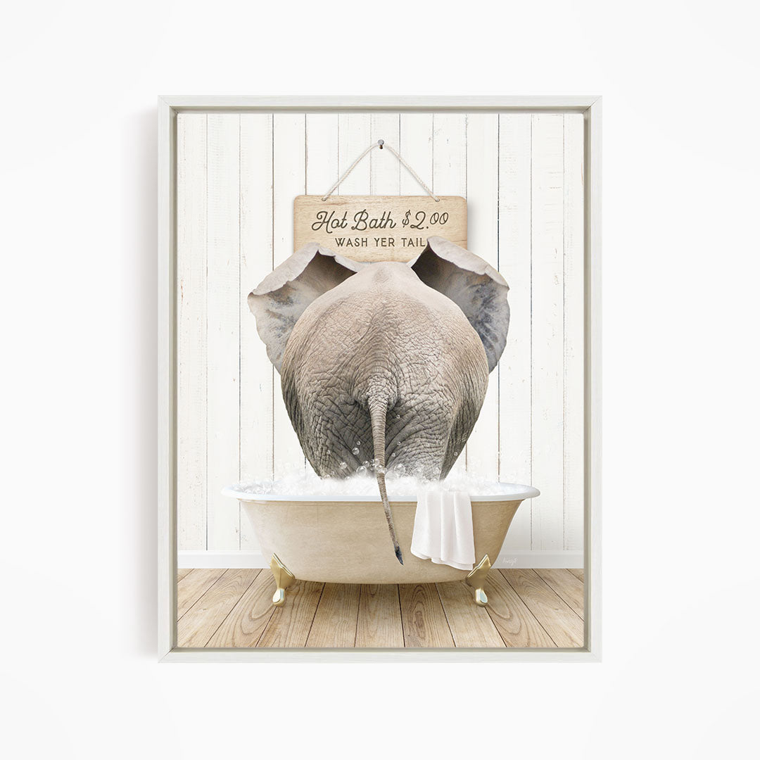 A framed image depicting an elephant standing in a bathtub, with a sign above it that reads "Hot Bath $2.00 WASH YER TAIL".